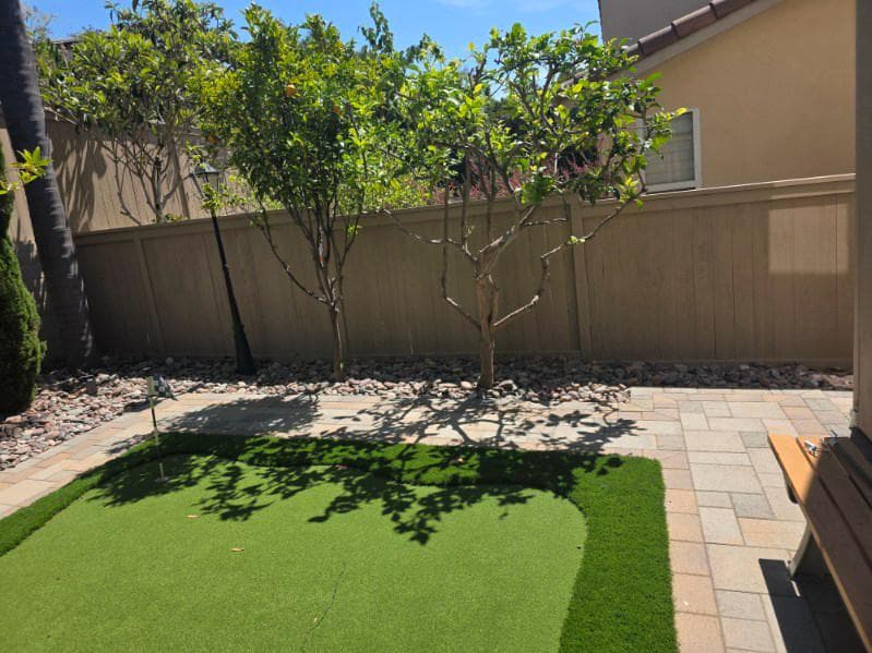 picture of a backyard project involving custom pavers and freshly installed turf